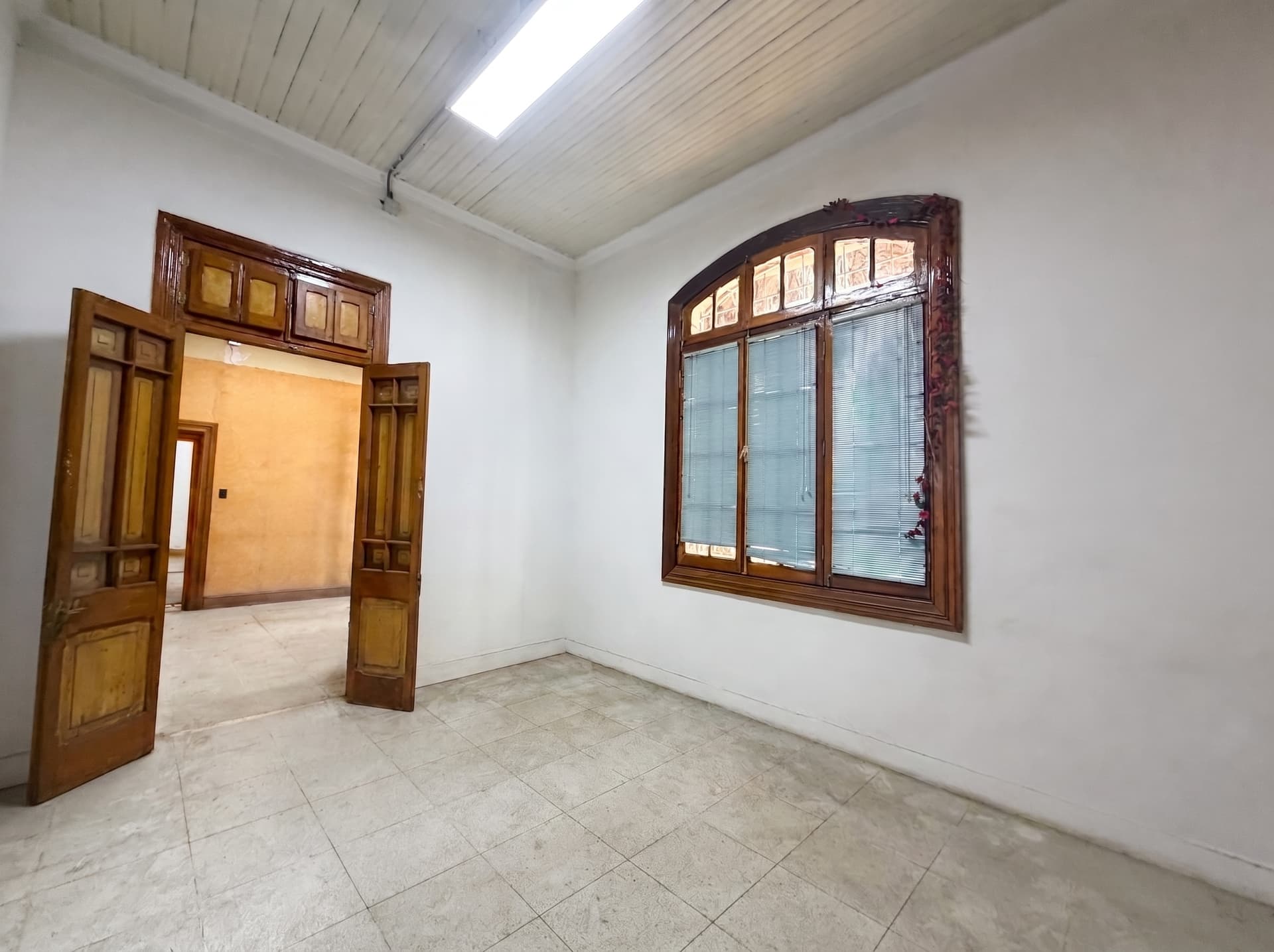 Espacio 1 en la sede Salvador, Ñuñoa — Sala luminosa de techo alto, con puertas de madera originales y ventana en arco. Ideal para atelier o estudio.